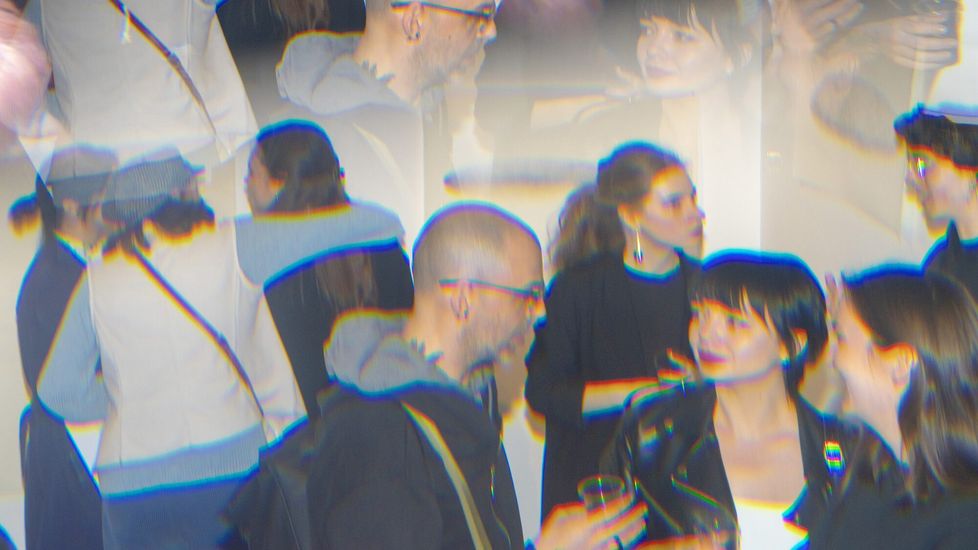 Photograph with a kaleidoscopic effect showing people at an art exhibition opening.