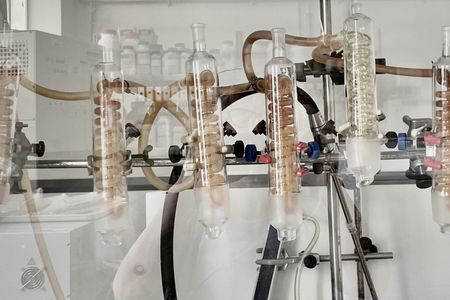 Photograph from a laboratory showing part of an apparatus with six vessels containing spiral-shaped tubes.